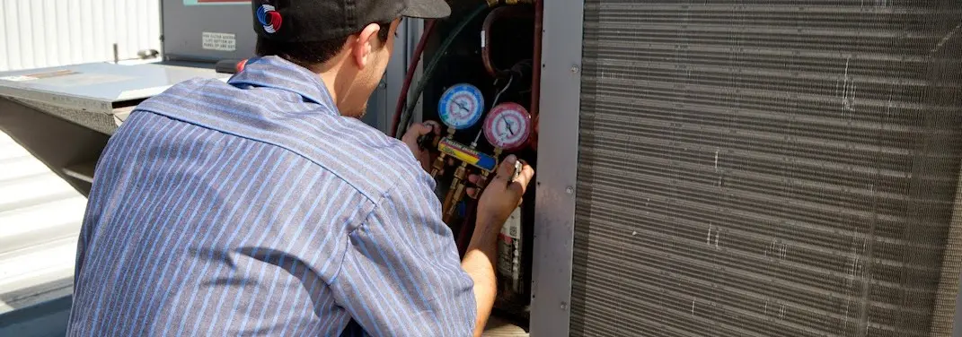 HVAC technician servicing a condenser unit in Wheatfield