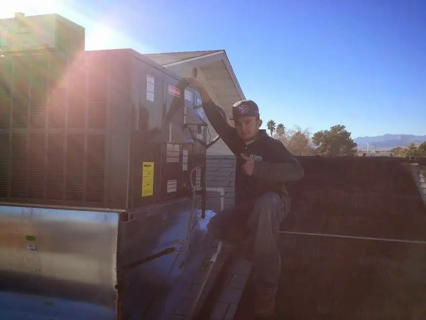 HVAC technician performing Air Duct Cleaning on a rooftop unit in Wheatfield